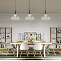 Clear bell glass pendant lights above a dining table; each pendant sold individually