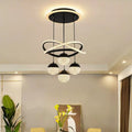 Black LED chandelier with intersecting rings and four acrylic globes in a dining room